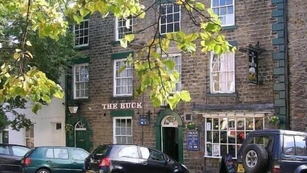 A building with a sign reading "THE BUCK" and a parked car in front. - The Buck INN (Richmond)