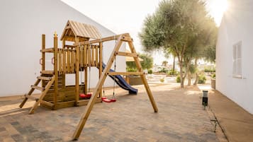 Children can play on the slide and swing set in this outdoor play area.