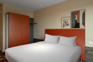 أغطية فراش متميزة وخزنة داخل الغرفة ومكتب وتجهيزات عازلة للصوت