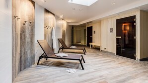 A modern spa area with two reclining chairs, a skylight, and a wooden wall. - Spark by Hilton Lyon Eurexpo (Genas)