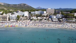 A beach with clear blue waters, numerous umbrellas, and people enjoying the sun. - Hotel HSM Linda Playa (Calvia)
