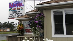 Un motel con un cartel que anuncia 'Sea Haven Motel' y 'Bienvenido Grupo Centro de Salmón Silvestre'.