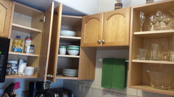 Una cocina con armarios de madera, una cafetera y diversos utensilios de cocina.