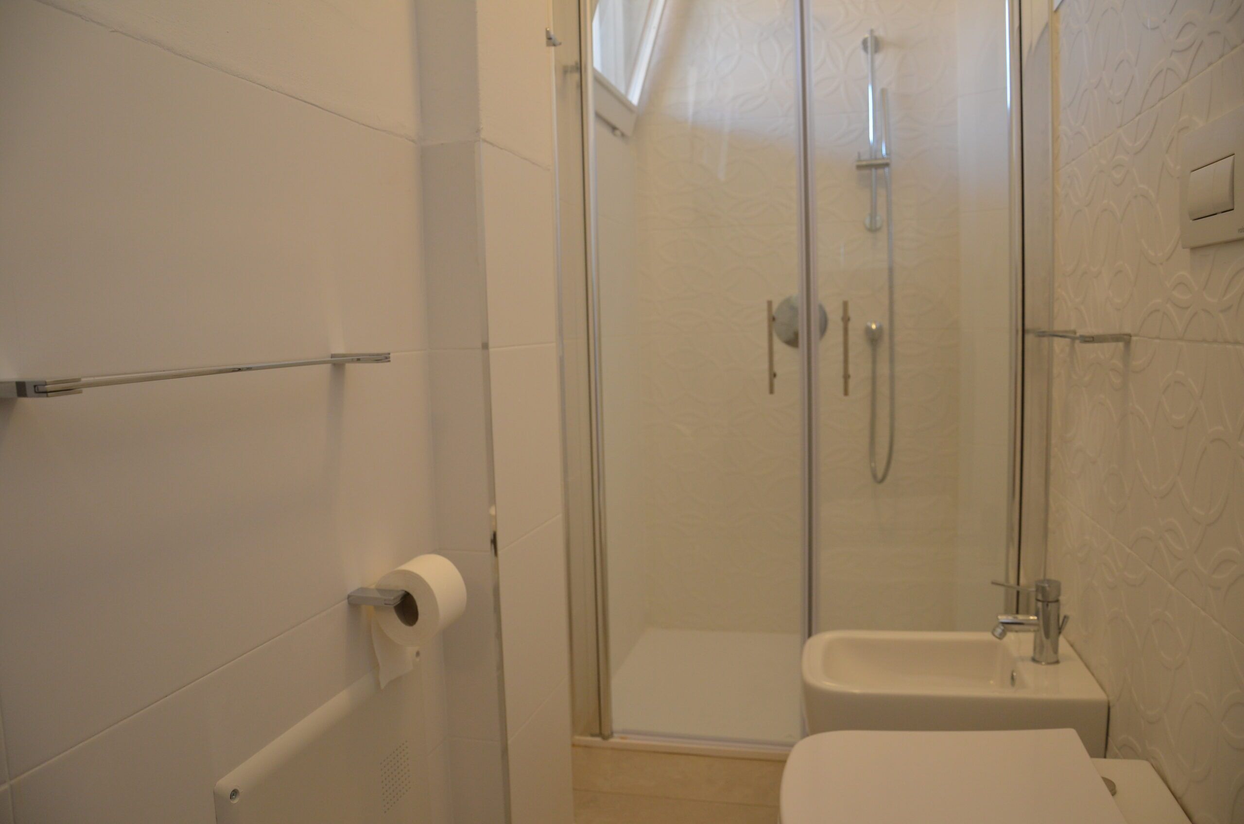 Une salle de bain avec une douche à parois de verre, des toilettes et un lavabo.
