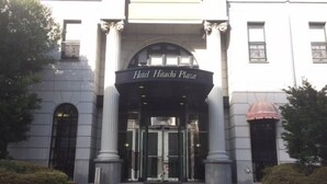 The entrance of Hotel Hibiuchi Plaza with a grand archway, steps leading up to the entrance, and a sign above the doors. - Hotel Hitachi Plaza (Hitachi)