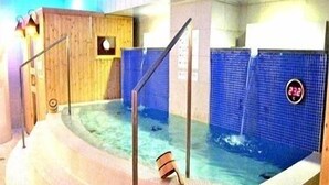 A hot tub area with a wooden deck and a blue tiled wall. - Hotel Hitachi Plaza (Hitachi)