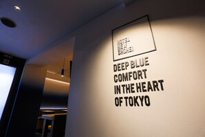 A wall with the text "HOTEL NEW SHOEI DEEP BLUE COMFORT IN THE HEART OF TOKYO". - Hotel New Shohei (Tokyo)
