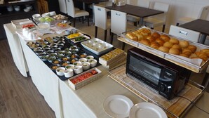 A buffet setup with various food items and a microwave.