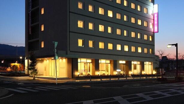 A multi-story hotel with illuminated windows and a prominent sign on the side.