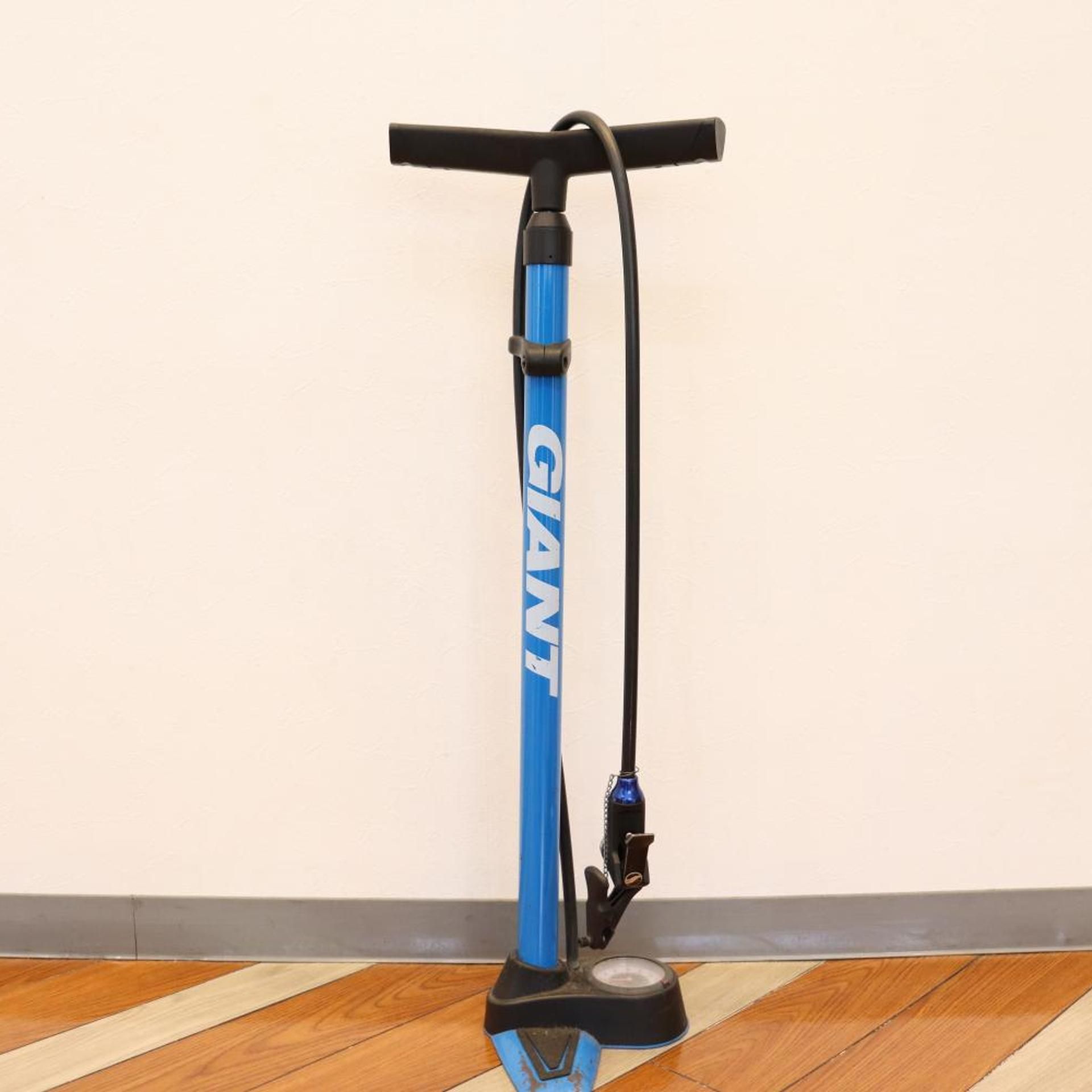 Una patineta eléctrica azul con manillar y cable de carga.