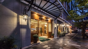 A hotel entrance with a covered walkway, potted plants, and a visible sign. - Hotel Gimmond Kyoto (Kyoto)