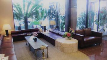 A spacious living area with a sofa set, a coffee table, and a round side table.