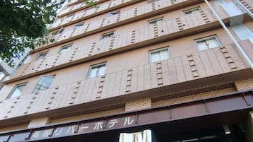 A multi-story building with a brick facade and multiple windows.