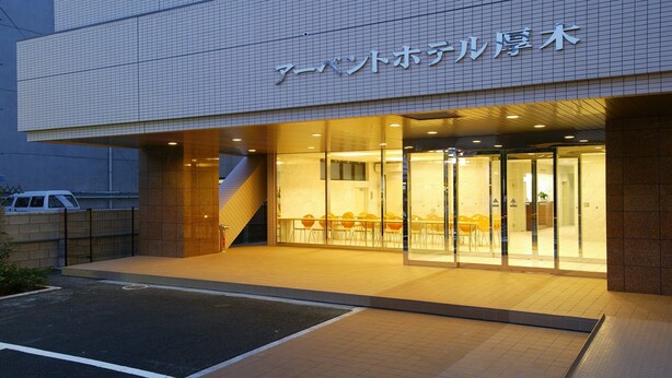 A hotel entrance with a tiled facade and a glass door leading inside. - R-bend Hotel ATSUGI (Atsugi)
