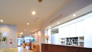 A reception area with a marble reception desk, a plant, and a wall-mounted key rack. - R-bend Hotel ATSUGI (Atsugi)