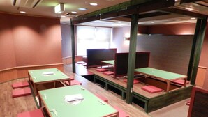 A conference room with green tables and red chairs, partitioned by wooden dividers. - Mimatsu Hotel (Mito)