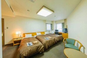 A hotel room with two beds, a desk with a television, a chair, and a small table. - Mimatsu Hotel (Mito)