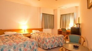 A hotel room with two beds, a desk, a chair, and a small table. - Mimatsu Hotel (Mito)