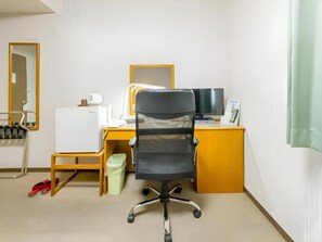 A hotel room with a desk, chair, and a small trash bin. - Mimatsu Hotel (Mito)