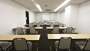 A conference room with long tables and chairs, a whiteboard, and a projector screen. - Smile Hotel Otsu Seta (Otsu)
