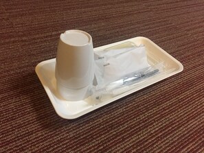 A white tray with a razor and a razor case on a brown carpeted floor.