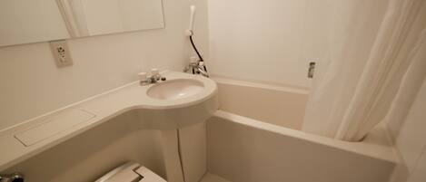 A bathroom with a toilet, sink, and bathtub.