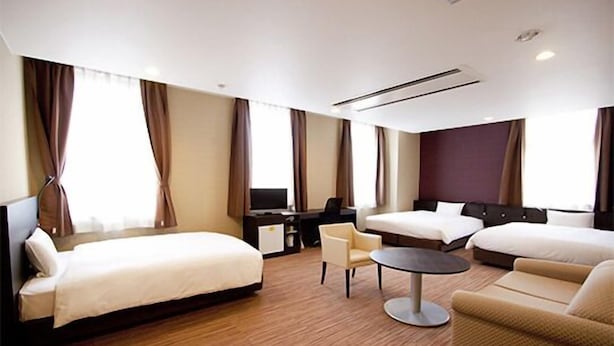 A hotel room with two beds, a desk, a chair, and a small table. - Smile Hotel Otsu Seta (Otsu)