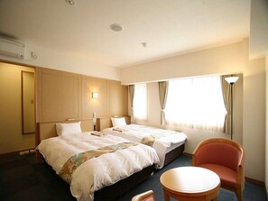 A hotel room with a large bed, a chair, and a small table. - Aioi Station Hotel (Aioi)
