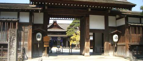 A traditional Japanese gate with wooden pillars and a tiled roof.