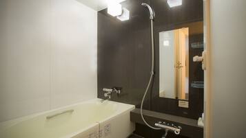 A modern bathroom with a bathtub, a shower, and a large mirror.