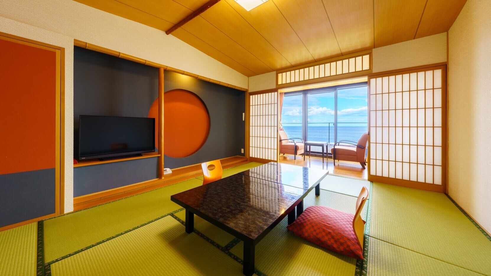 Um quarto japonês tradicional com tatames, uma mesa baixa e portas deslizantes.