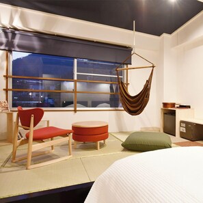 A modern room with a bed, a hanging chair, a small table, and a window with a view. - Ryokan Furuyu Onsen Ogiya (SAGA SHI)