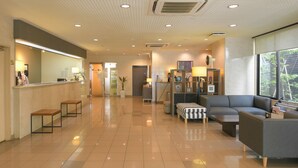 A hotel lobby with a reception desk, seating area, and a large window offering a view. - Shonandai Dai-Ichi Hotel Fujisawa Yokohama (Fujisawa)