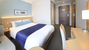 A hotel room with a bed, bedside table, lamp, and a desk with a chair. - Shonandai Dai-Ichi Hotel Fujisawa Yokohama (Fujisawa)