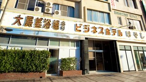 A multi-story hotel with a sign indicating it is a business hotel. - Beppu Ekimae Hotel Hayashi (Beppu)