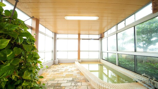 A spa area with a tiled floor, a hot tub, and large windows. - Beppu Ekimae Hotel Hayashi (Beppu)