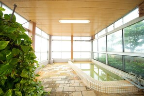 A spa area with a tiled floor, a hot tub, and large windows. - Beppu Ekimae Hotel Hayashi (Beppu)