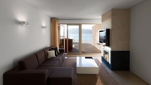 Un soggiorno moderno con un divano, un tavolino da caffè e una TV a schermo piatto montata a parete.