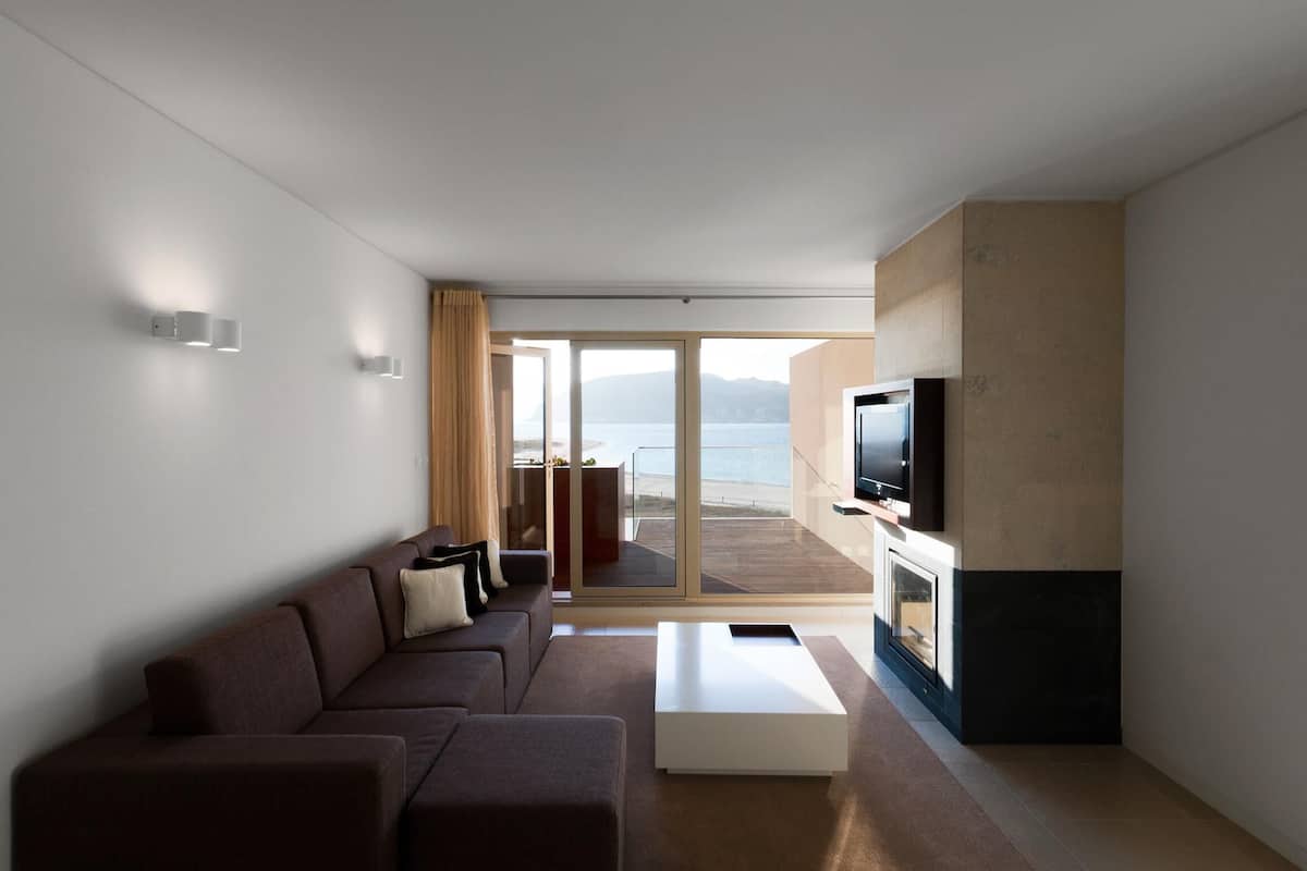 Una sala de estar moderna con un sofá, una mesa de centro y un televisor de pantalla plana montado en la pared.