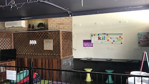 A children's room with a play area, a sign indicating a 'Kids Room', and a 'Smile' sign on a partition. - Tin Can Bay Budget Accommodation - Hostel (Tin Can Bay)