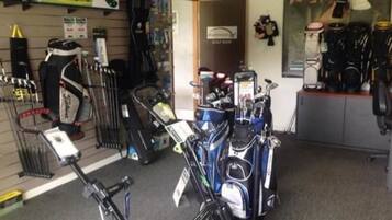 A golf equipment store with various golf clubs and bags displayed on shelves and racks.