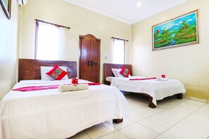 A hotel room with two beds, a painting on the wall, and a wooden wardrobe. - Jungut Guest House By Zuzu (Ubud)