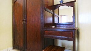 A wooden wardrobe with a mirror and a small shelf. - Jungut Guest House By Zuzu (Ubud)