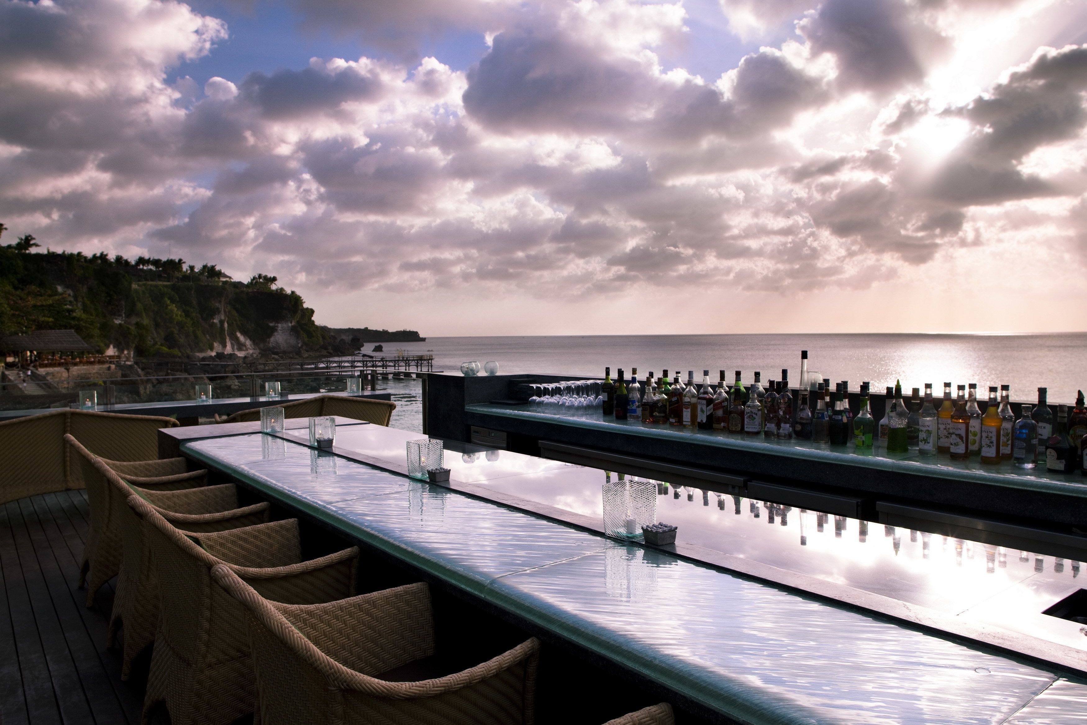 A bar with a glass top overlooking a coastal view.