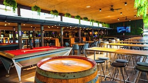 A pool table, bar stools, and hanging plants in a restaurant setting. - Park Beach Hotel Motel (Coffs Harbour)