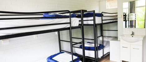 A bunk bed room with a white sink and mirror.