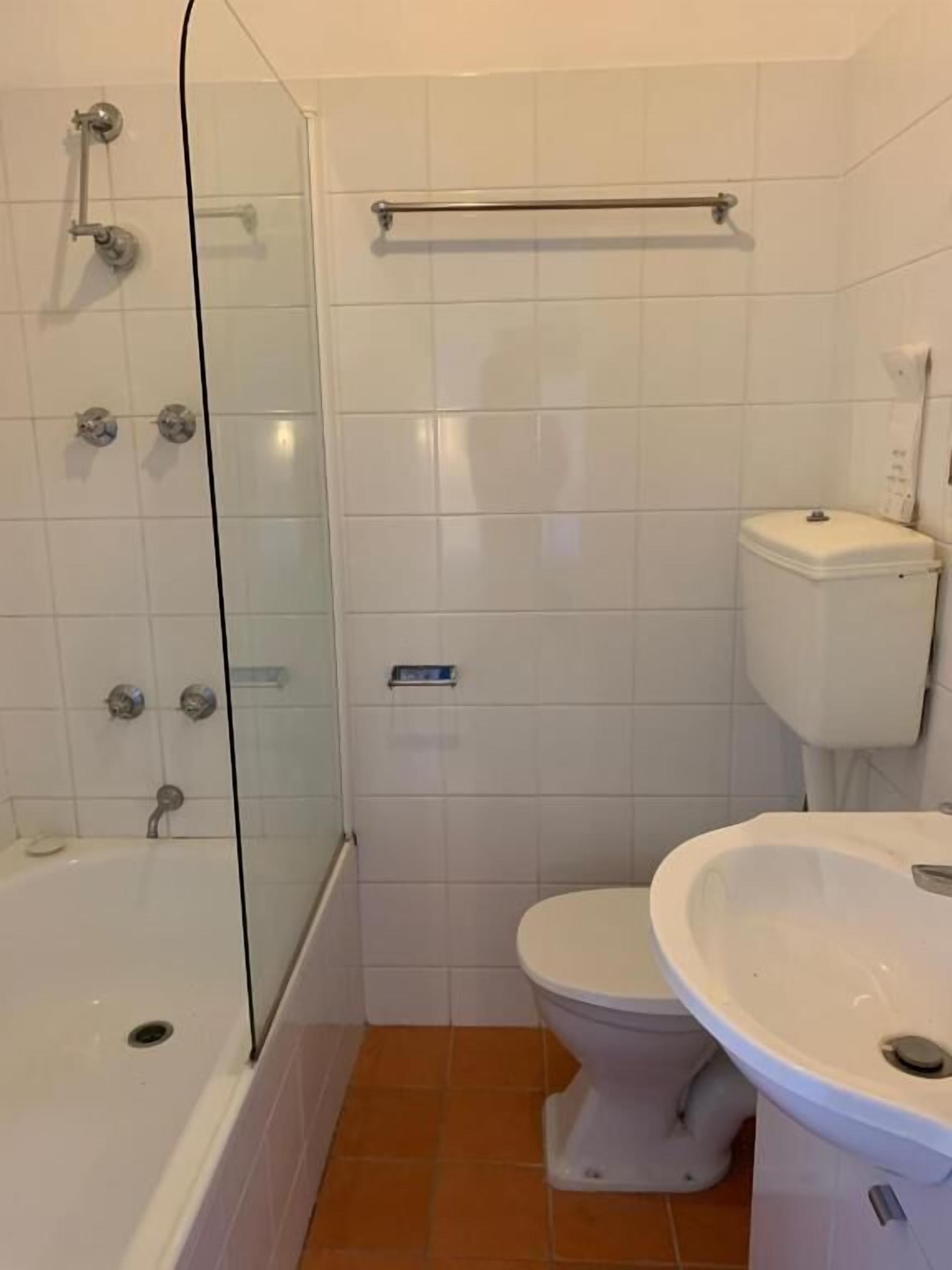 Ein Badezimmer mit Duschkabine, Toilette und Waschbecken.