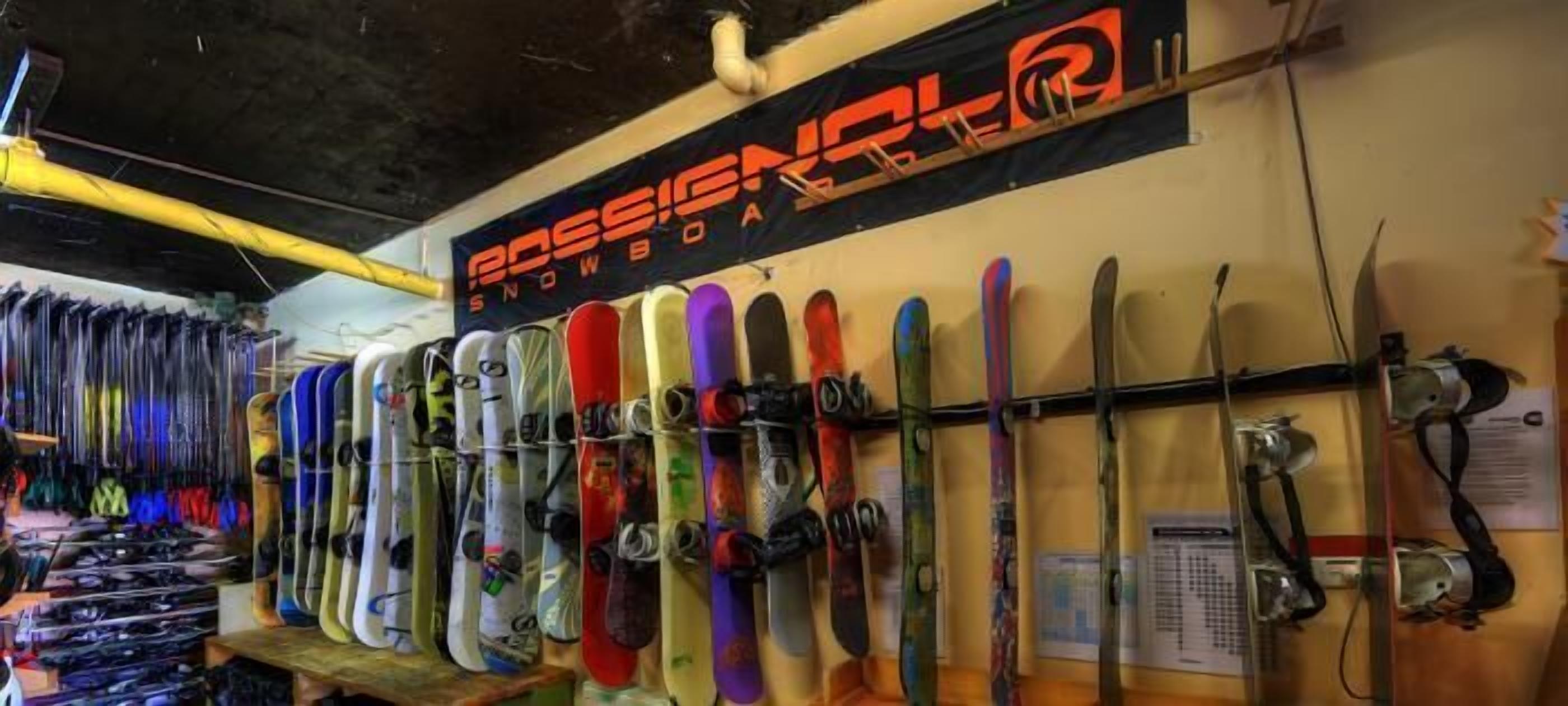 Un magasin de planches à neige où une grande variété de planches sont exposées sur des présentoirs.