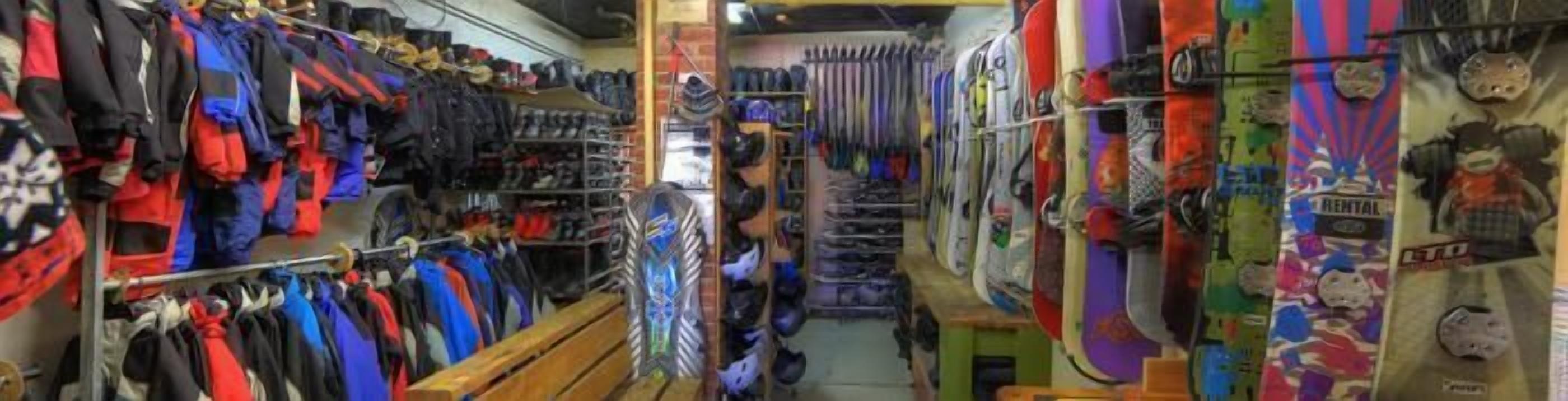 A narrow corridor with racks of colorful clothing and helmets.