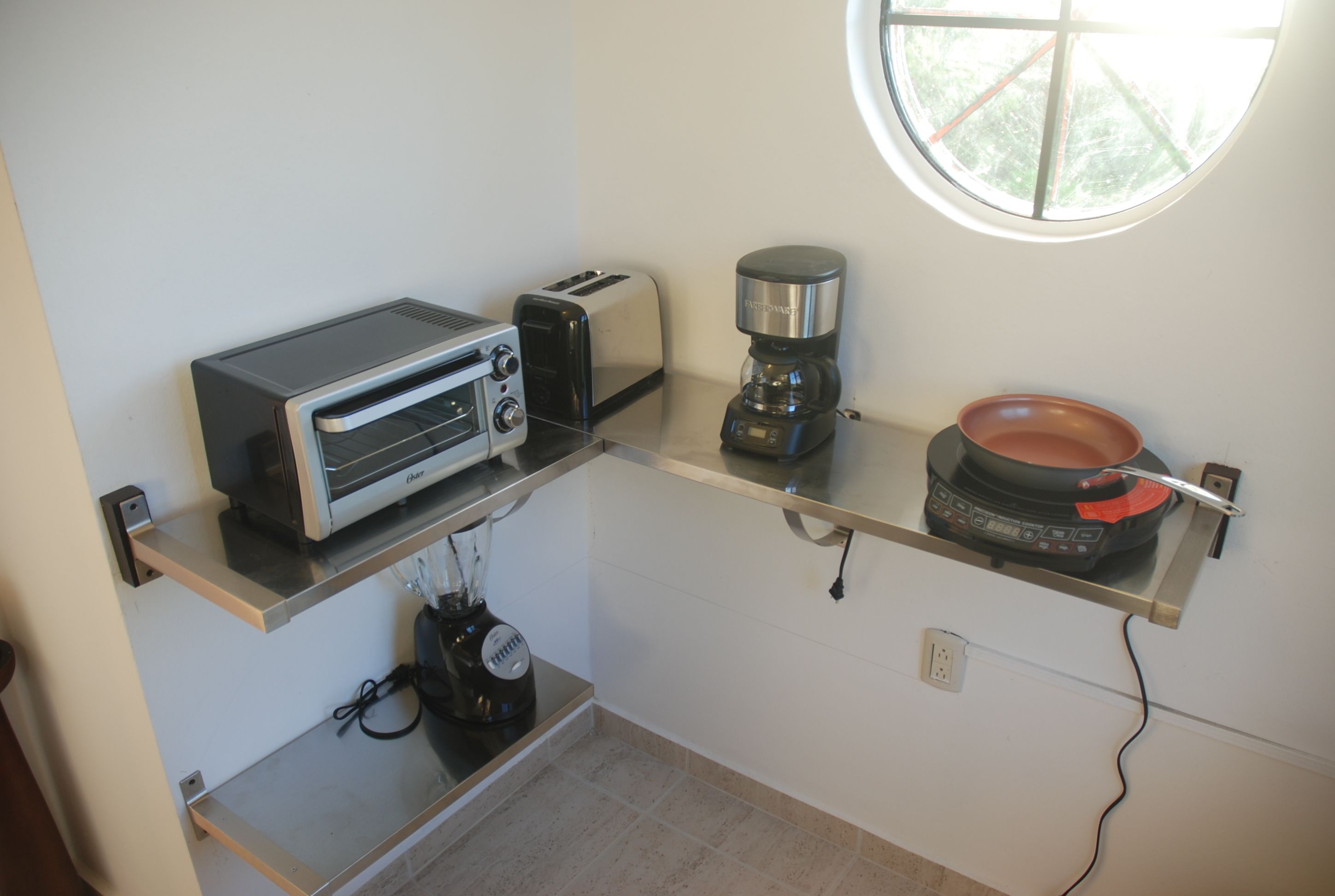 Eine Küchenzeile mit Toaster, Kaffeemaschine und Kochtopf auf der Arbeitsfläche.
